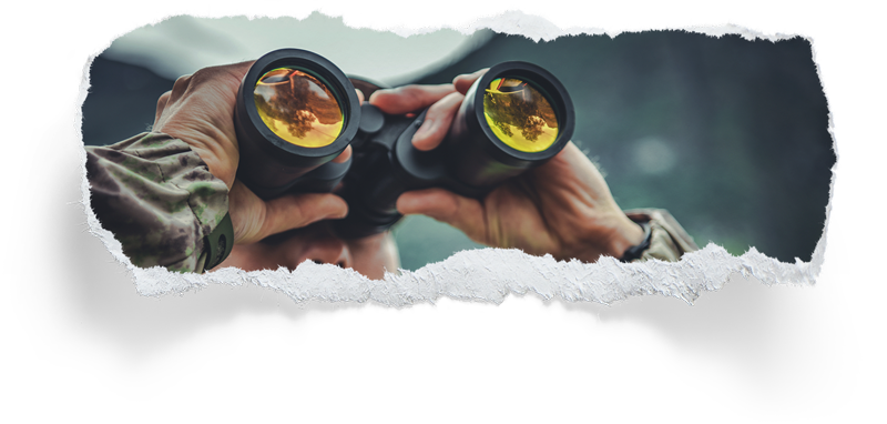 Man in camo looking through binoculars